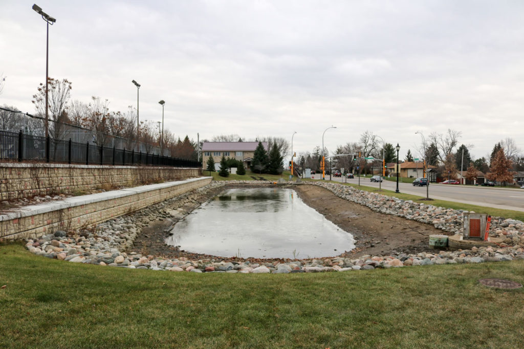 The stormwater retention pond (seen here partially drained) sits above the underground storage tank.