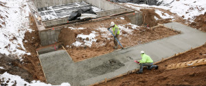 Workers smooth freshly poured concrete for the facility's foundation.