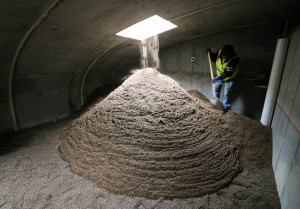 A worker uses a shovel to spread iron-enhanced sand in one of the secondary filtration chambers.