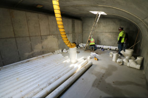 Workers install pipes in the chamber that will house the iron sand filter.