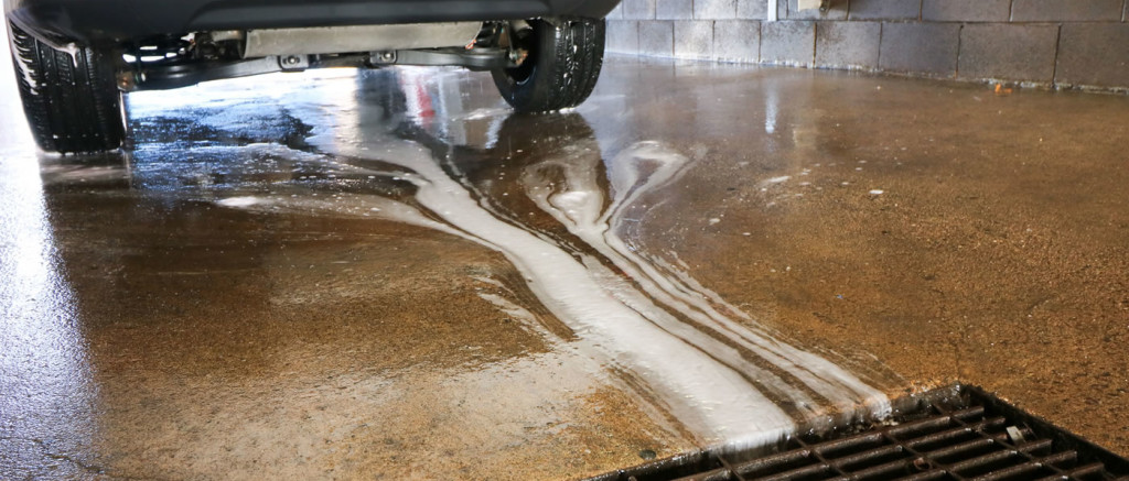 Soapy water entering a floor drain at a car wash.