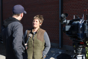 A TV news reporter interviewing a grantee on camera in October 2015.