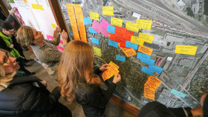 Workshop participants place sticky notes on a map of the Prospect North Light Rail Station area.