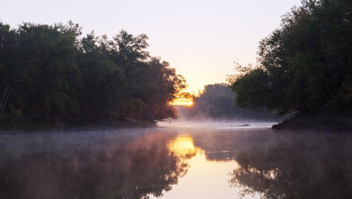 A misty river scene.