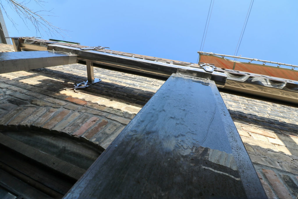 The runoff is conveyed through a decorative steel structure into a pair of dry wells.
