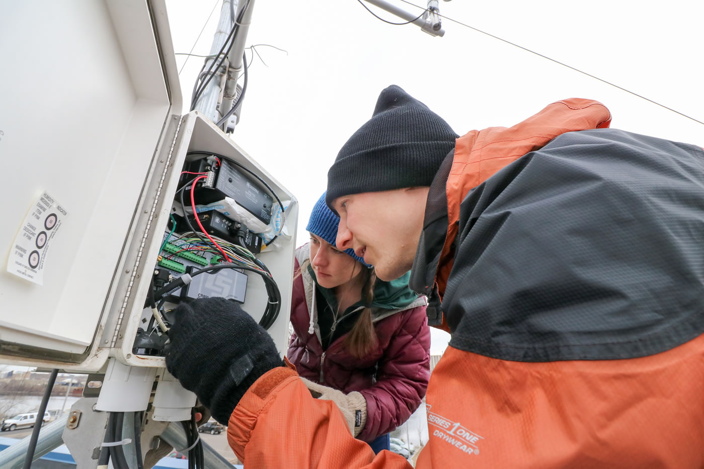 MWMO Water Resources Specialist Jen Keville and Environmental Specialist Brain Jastram work to repair the weather station on the roof of the MWMO Stormwater Park and Learning Center in March 2016.