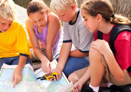 Children use a map and a GPS device.