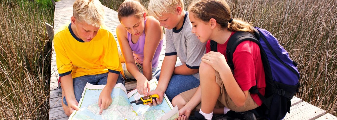 Children use a map and a GPS device.