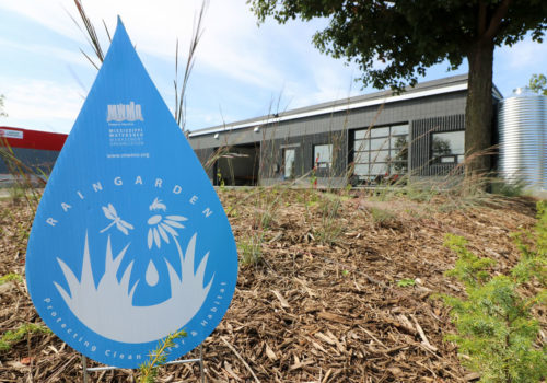 An MWMO raingarden sign in front of the Fourth Street Guild.