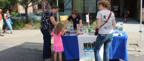 An MWMO intern greets visitors during Open Streets Nicollet.