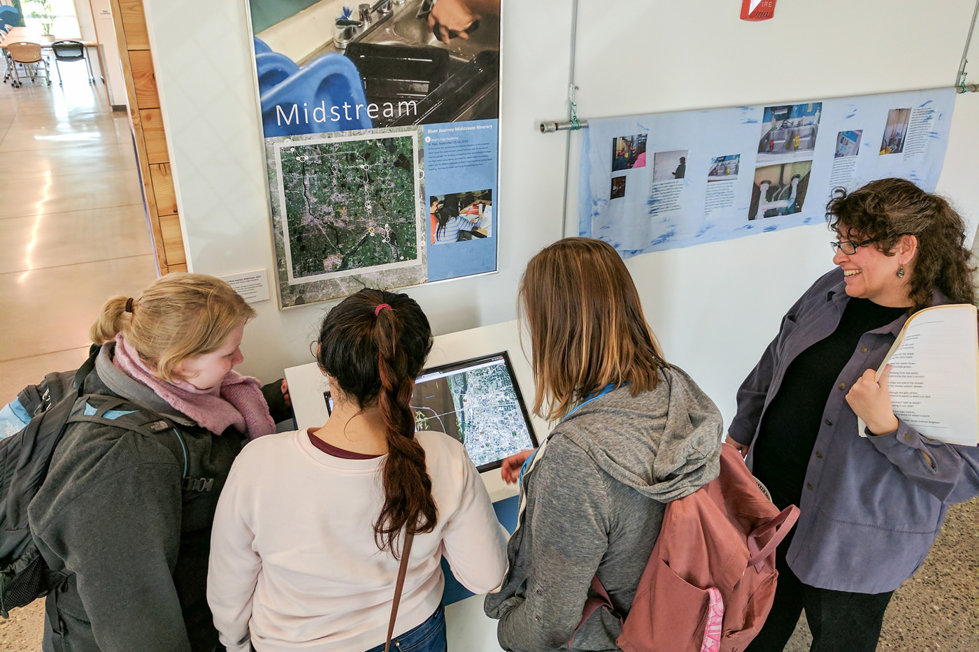 Students gathered around a touch-screen display.