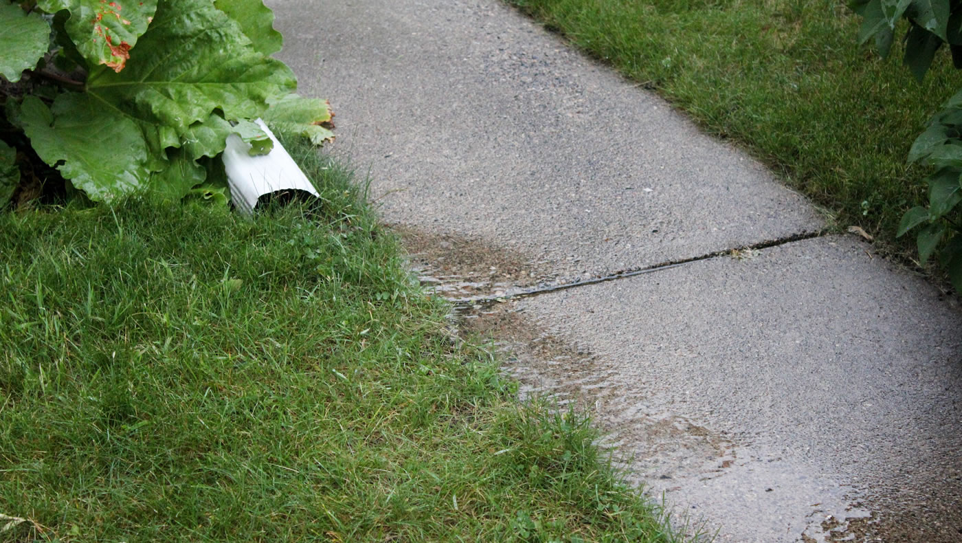 Downspout discharging onto sidewalk