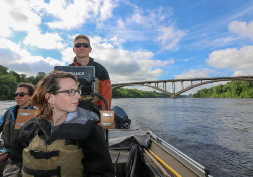 MWMO monitoring team members boating across the Mississippi River to the next sampling site.