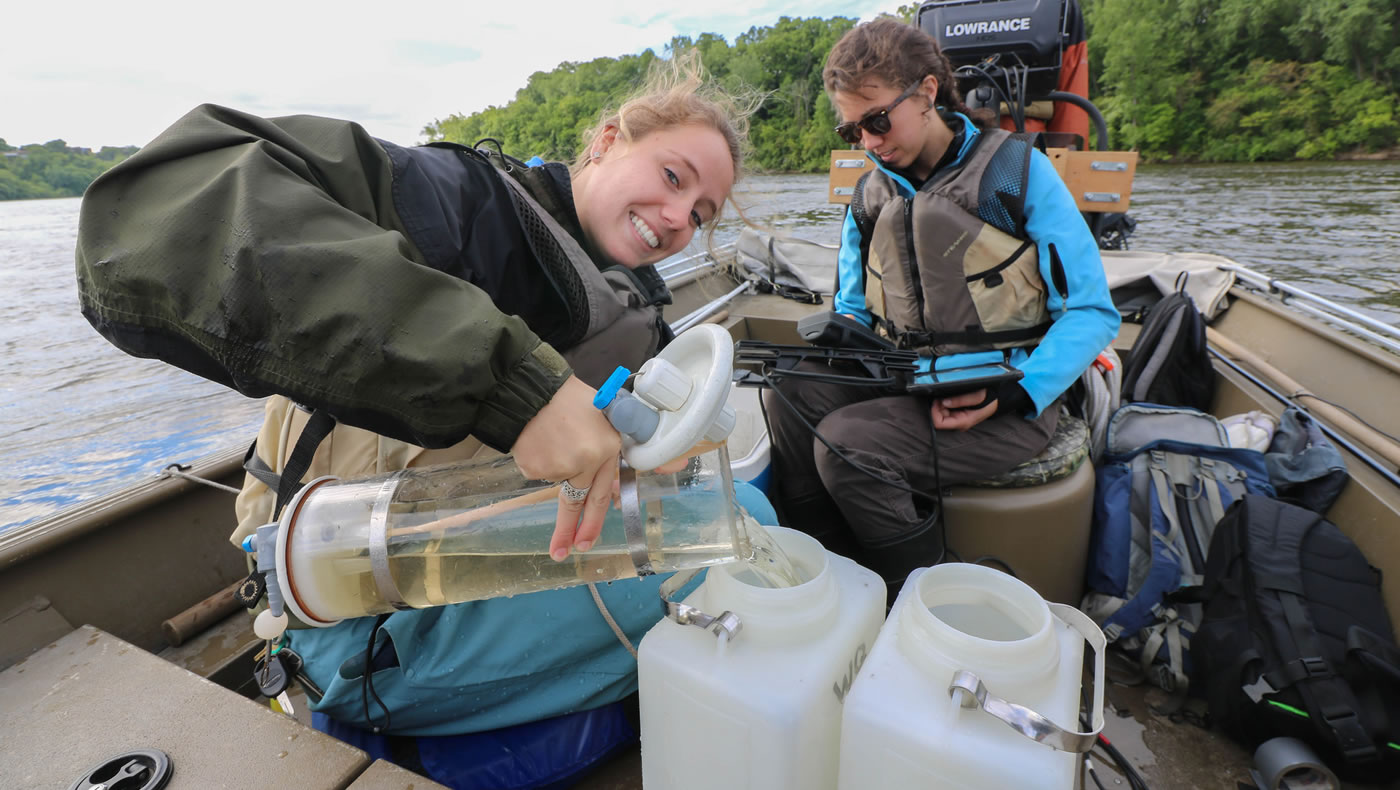 Monitoring team member pours the water samples into plastic jugs that the monitoring team will deliver to the Metropolitan Council Environmental Services Laboratory shortly after returning to shore. 