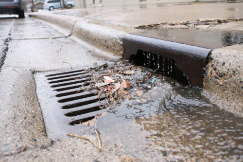 Polluted runoff flowing into a stormdrain.