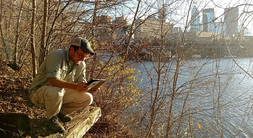 Ecologist Alex Roth of Friends of the Mississippi River takes inventory of vegetation on Nicollet Island.