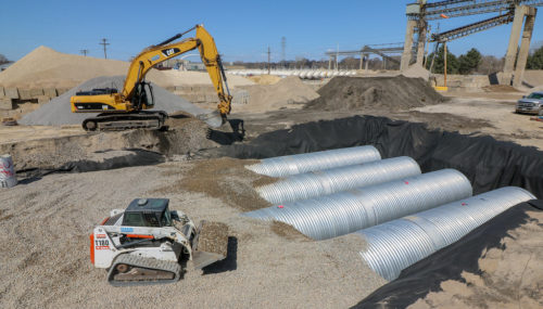 Workers installing the stormwater reuse tanks at Cemstone on April 26, 2018.