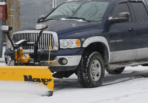 Pickup truck outfitted with snow plow in winter.