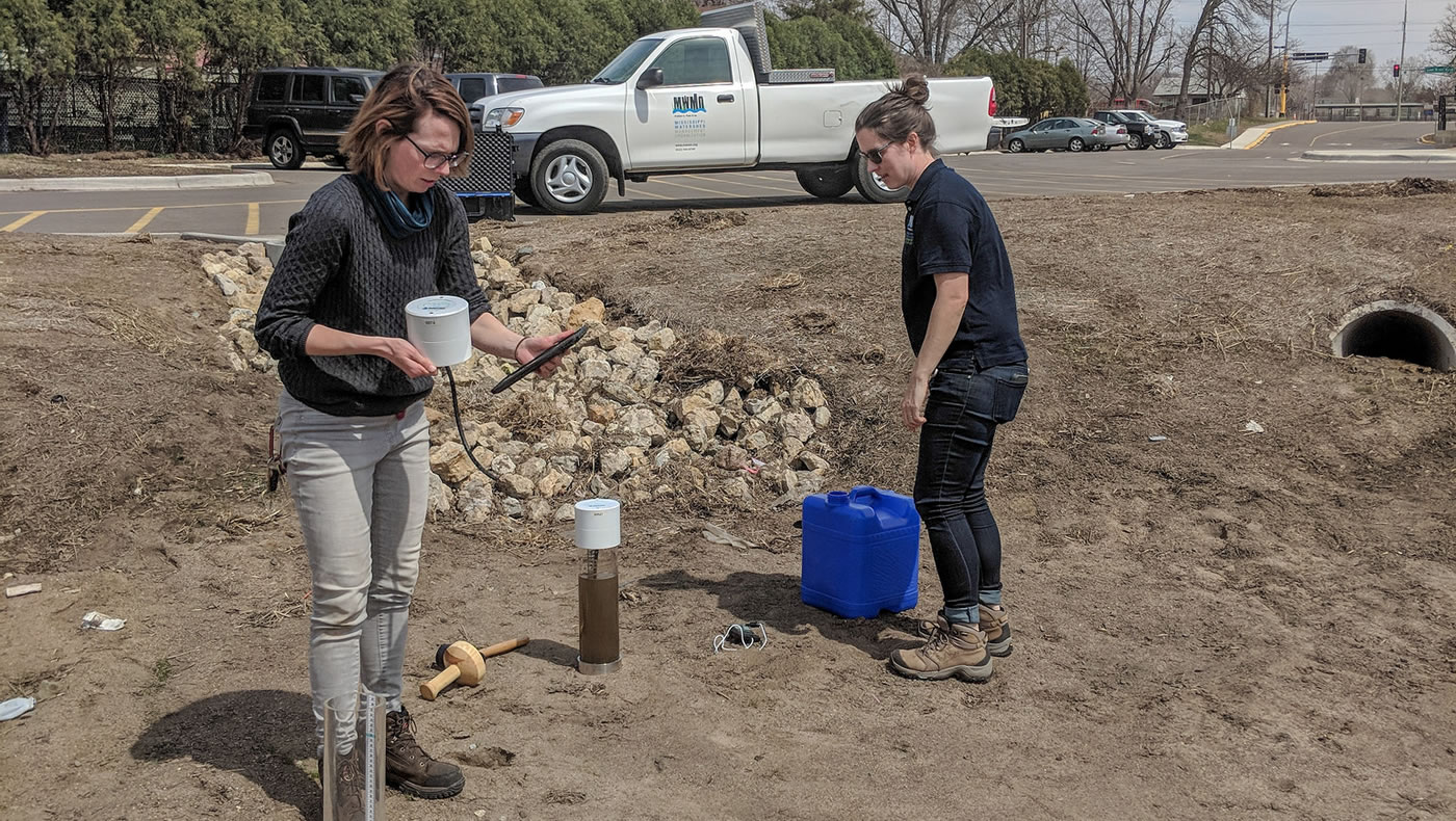 MWMO monitoring team staff use an infiltrometer to measure the raingarden's capacity to infiltrate water.
