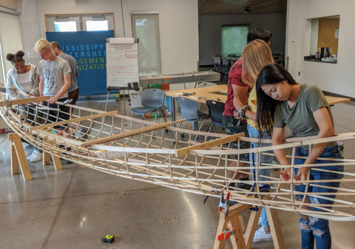Mississippi River Green Team members working on the Urban Boatbuilders canoe.