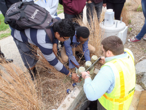 Students learn how to collect water quality samples from the tree trench at Edison High School.