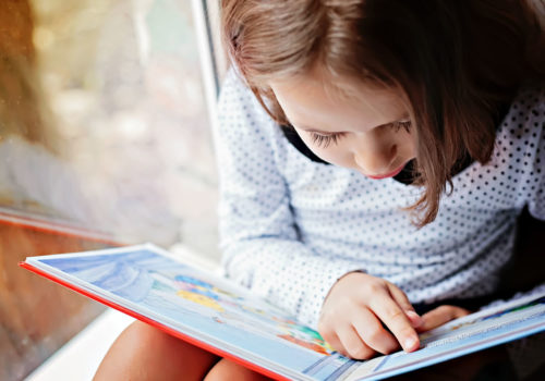 Close-up photo of a girl reading a book. (Shutterstock)