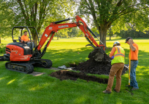 An engineer examines an excavated pit at the Columbia Golf Course.