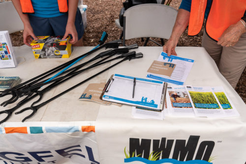 A sign-up form and materials on a table at a community cleanup event.