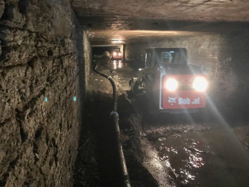 Workers use loaders to remove sediment from the Old Bassett Creek Tunnel.