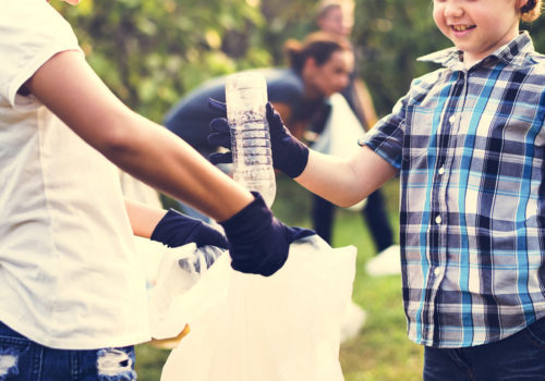 Youth cleaning up trash in a park.