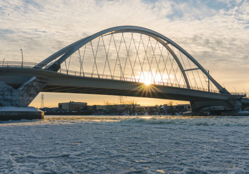 The Lowry Avenue Bridge towers over an icy Mississippi River.