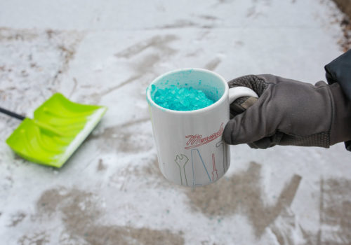 A coffee mug filled with blue salt granules.