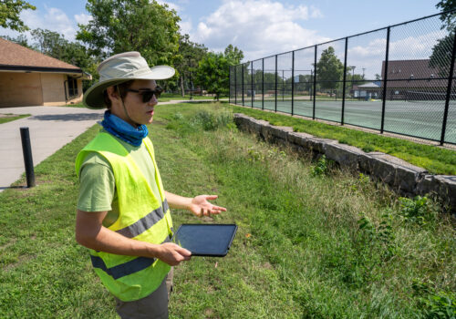 GRIIT member Noah Sullivan inspects a stormwater infiltration basin at Webber Park in North Minneapolis.