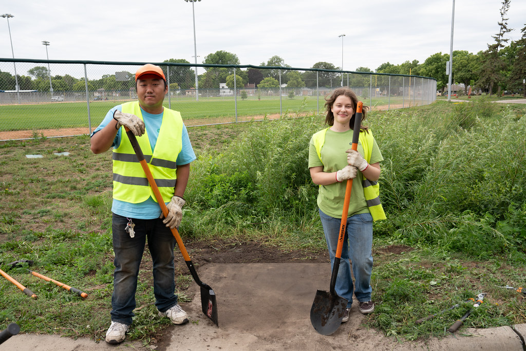 Vang and Hylton pose after clearing an inlet to a stormwater infiltration feature.