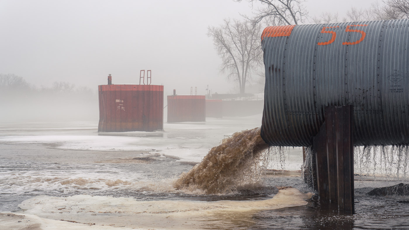 Dirty stormwater runoff gushes from an outfall into the Mississippi River in Minneapolis.