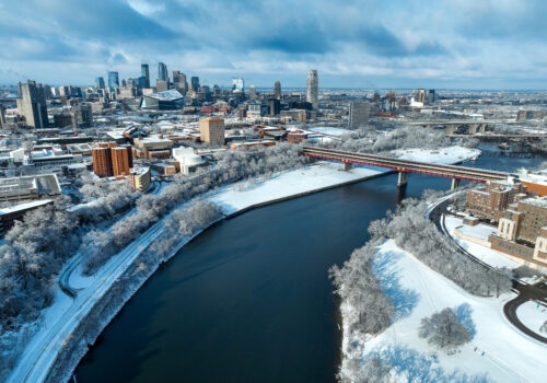 Downtown Minneapolis Winter Aerial of the Mississippi River at the Washington Bridge with the Minneapolis city skyline in the background.