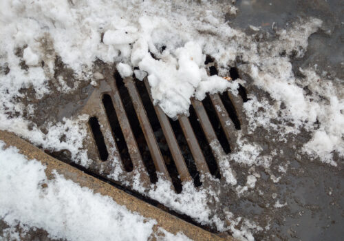 Storm drain covered by melting snow