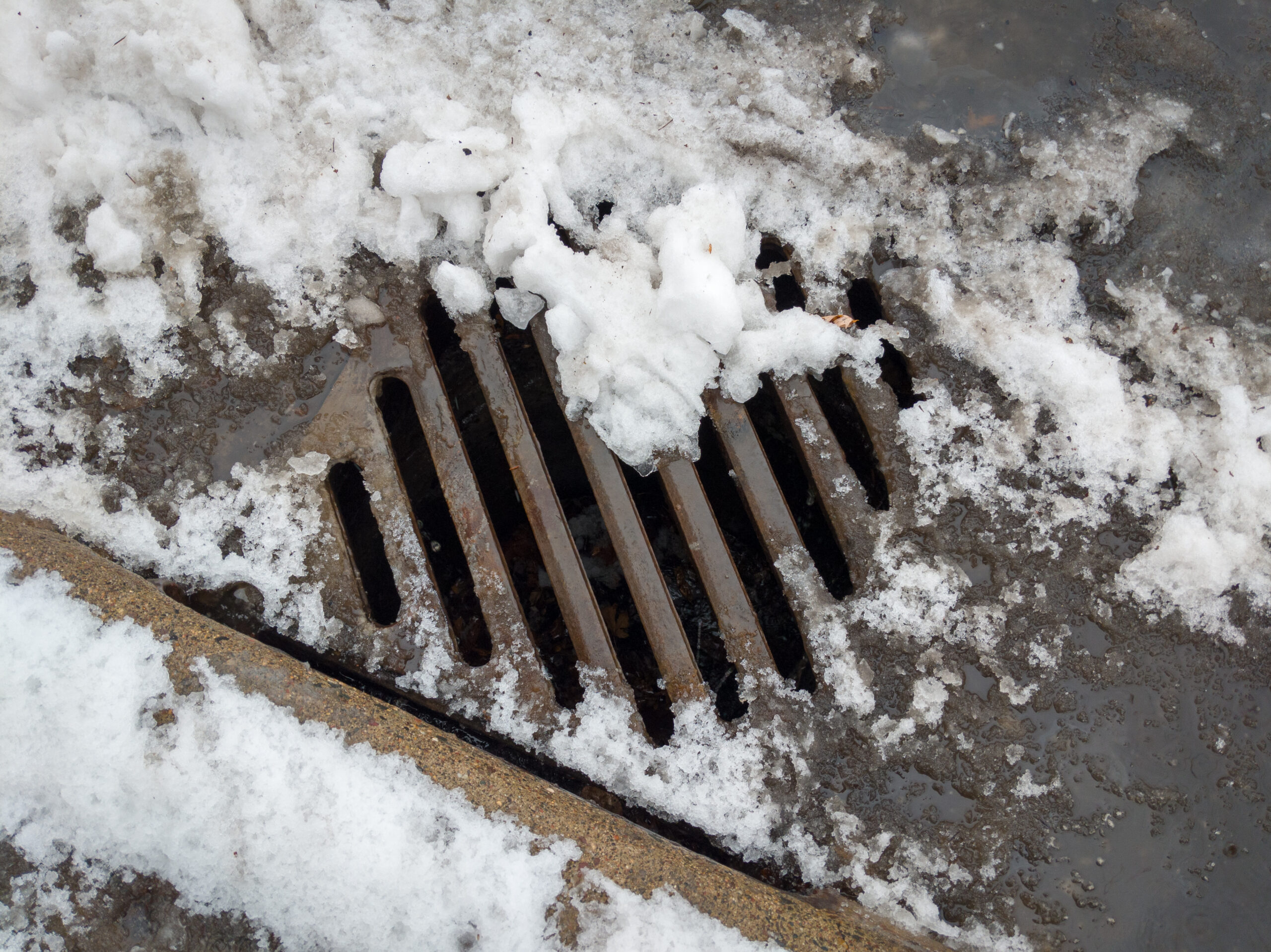 Storm drain covered by melting snow