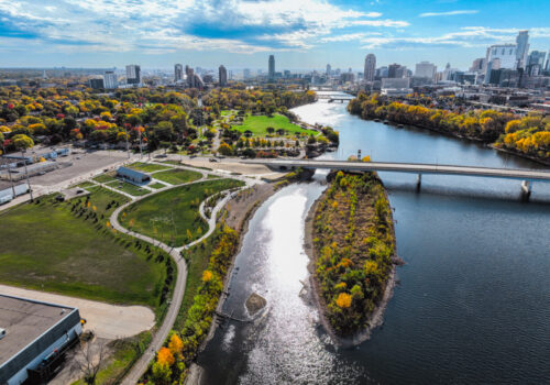 An aerial view of Graco park and Hall's Island on the Mississippi River with the Minneapolis skyline in the back
